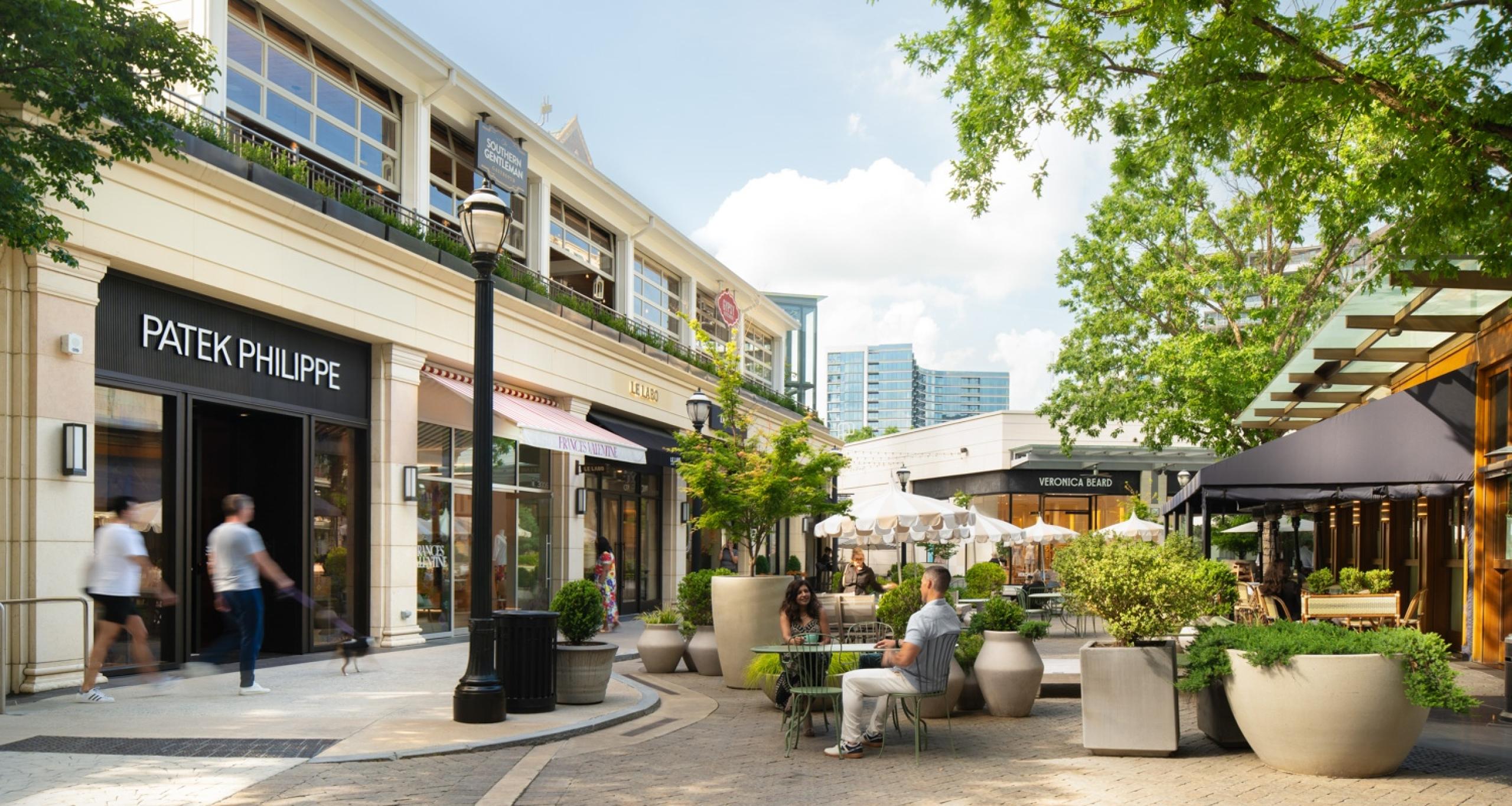Visitors walking the streets of Buckhead Village and sitting in an outdoor courtyard between shops and restaurants