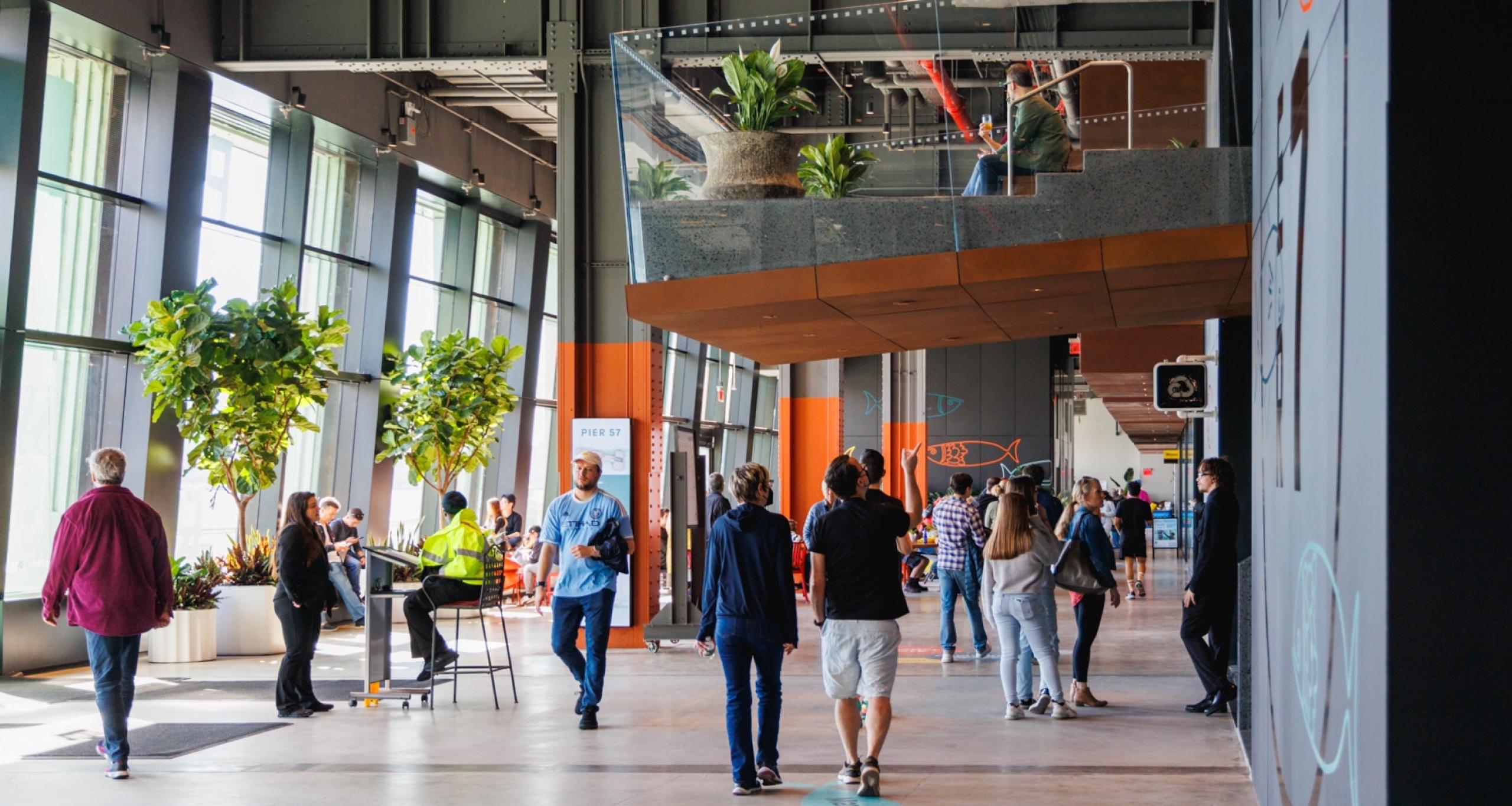 Visitors walking and sitting in a common area inside Pier 57