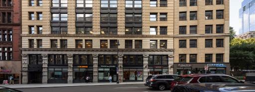 Cars and people walk by 18 Tremont in Boston