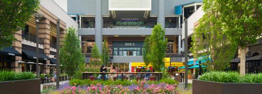 Visitors sitting in and walking through an exterior courtyard surrounded by shops at Ridge Hill