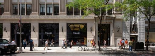 Exterior of first four floors of 136 Madison building with pedestrians on sidewalk in front
