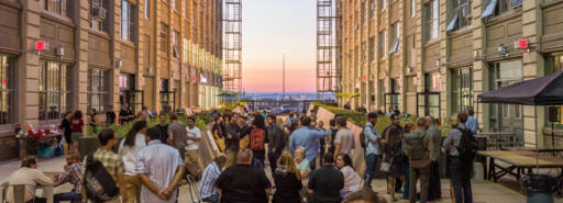 Industry City courtyard at dusk with attendees at an event
